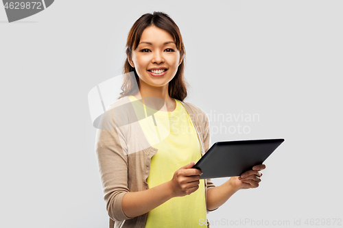 Image of happy asian woman using tablet computer