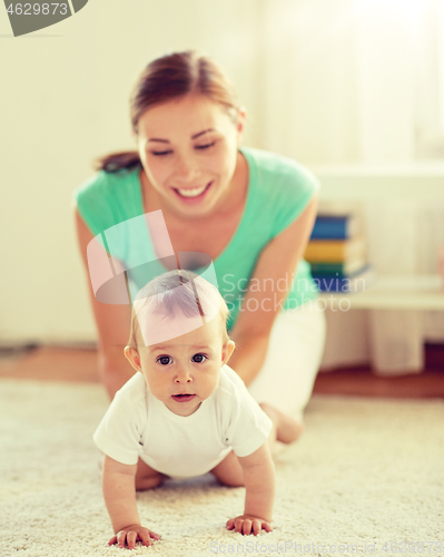 Image of happy mother playing with baby at home