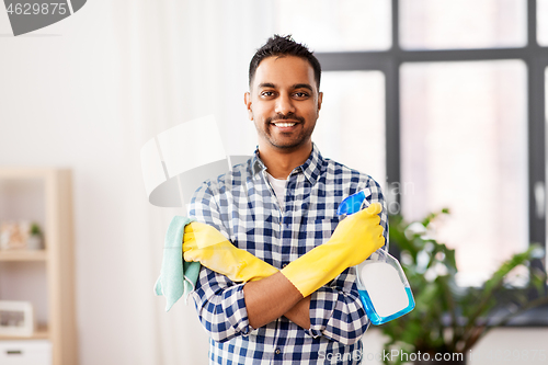 Image of smiling indian man with detergent cleaning at home