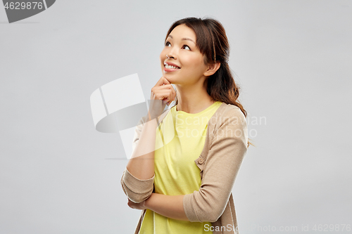 Image of happy asian woman over grey background