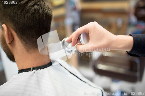 Image of barber with brush cleaning male neck at barbershop