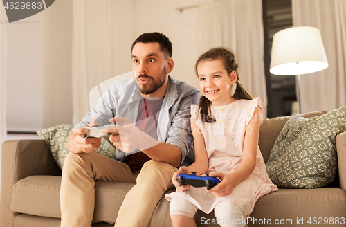 Image of father and daughter playing video game at home