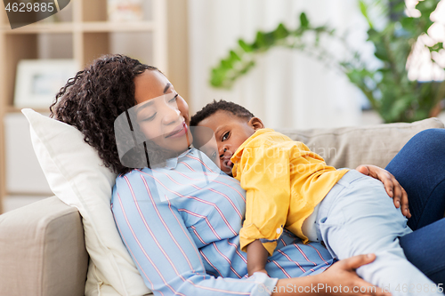 Image of happy african american mother with baby at home