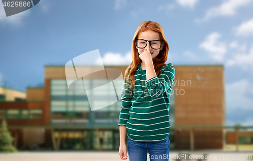 Image of red haired student girl in glasses over school