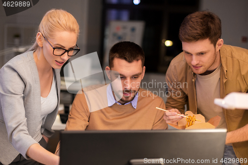 Image of business team with computer working late at office