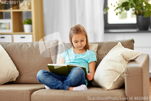 Image of little girl reading book at home