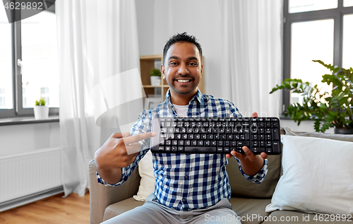 Image of male blogger with keyboard videoblogging at home