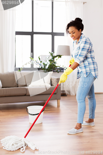 Image of african woman or housewife cleaning floor at home