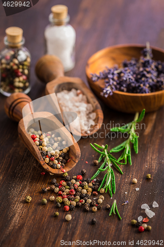 Image of Salt, pepper with rosamary and lavender on wooden background