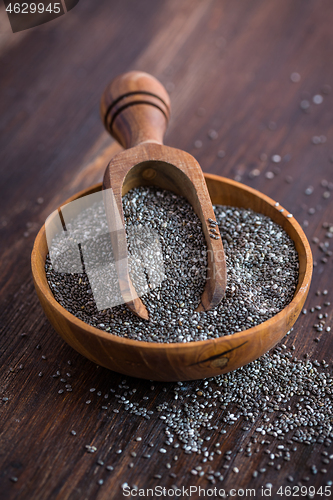 Image of Chia seeds with spoon in the bowl on the wooden background