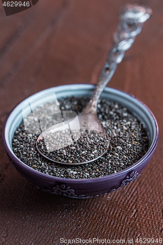 Image of Chia seeds with spoon in the bowl on the wooden background