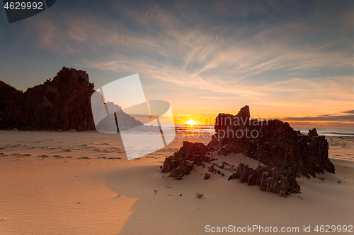 Image of Golden sunrise warm sunlight on the remote rocky beach