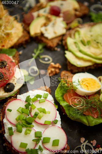 Image of Assortment of home made sandwiches with various toppings. With colorful fresh vegetables