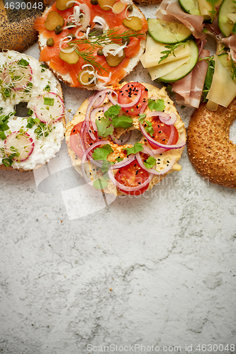 Image of Homemade Bagel sandwiches with different toppings, salmon, cottage cheese, hummus, ham, radish