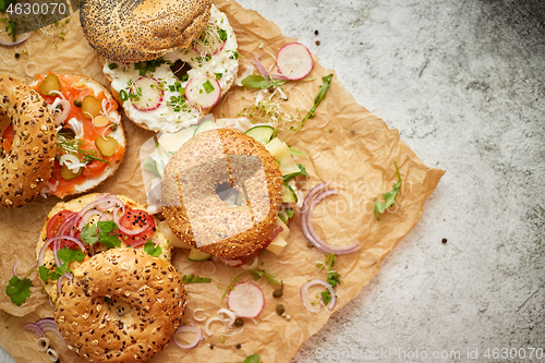 Image of Tasty colorful various bagels with healthy ingredients served on brown baking paper