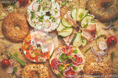 Image of Tasty colorful various bagels with healthy ingredients served on brown baking paper