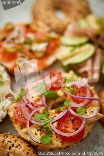 Image of Assortment of different kinds toppings homemade bagels sandwiches with sesame and poppy seeds