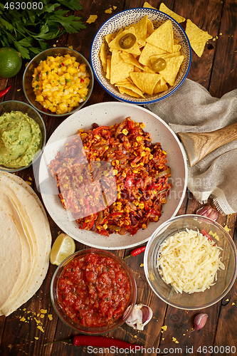 Image of Mexican food concept. Vegetable burritos. Served on pan. Tortilla guacamole, salsa, chilli and beans