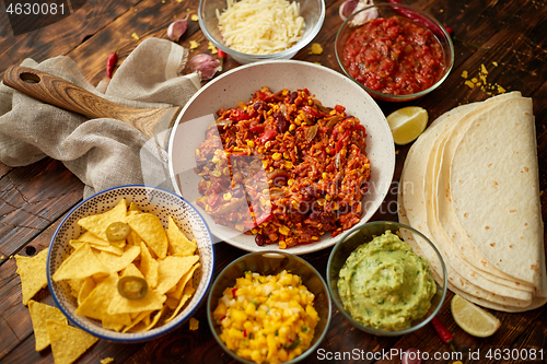 Image of Preparing vegetable burritos on white pan. With various ingredinets for mexican food