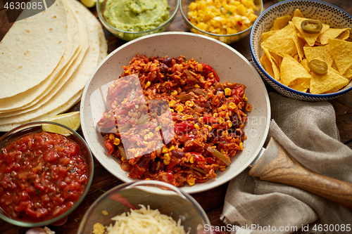 Image of Mexican food concept. Vegetable burritos. Served on pan. Tortilla guacamole, salsa, chilli and beans