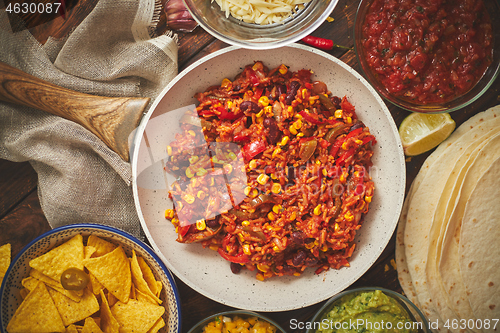 Image of Preparing vegetable burritos on white pan. With various ingredinets for mexican food