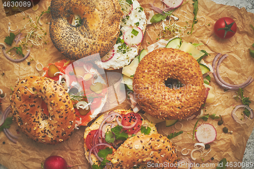 Image of Tasty colorful various bagels with healthy ingredients served on brown baking paper