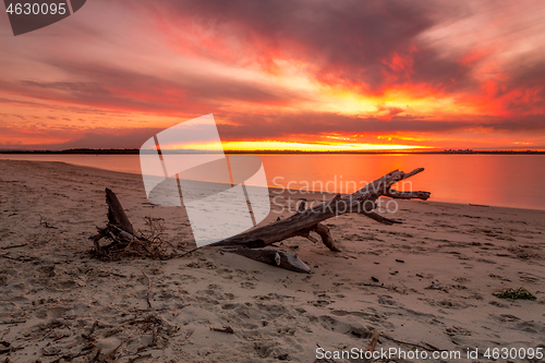 Image of Vivid strong orange and red colours of the sunset across the bea