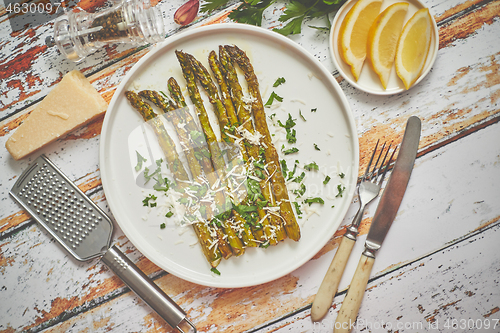 Image of Delicious roasted asparagus served on white ceramic plate. With 