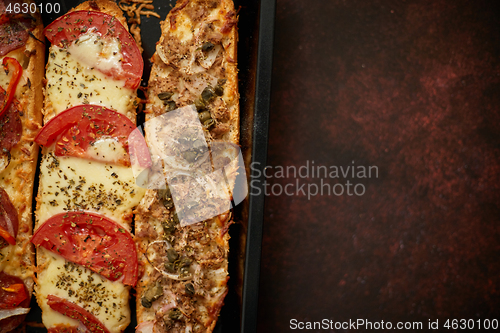 Image of Long baguettes pizza sandwiches with tuna, mushrooms, tomatoes a