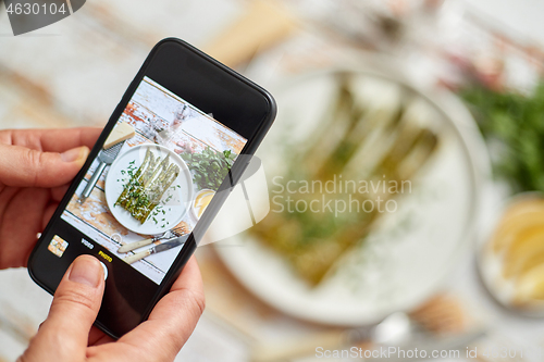 Image of Woman taking picture of fresh prepared food with smartphone for 