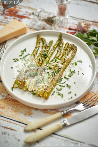 Image of Roasted asparagus with parmesan cheese and parsley. Healthy spring food concept. View from above.