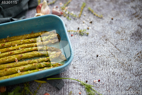 Image of Roasted asparagus seasoned with salt, pepper, garlic and decorated with fresh herbs