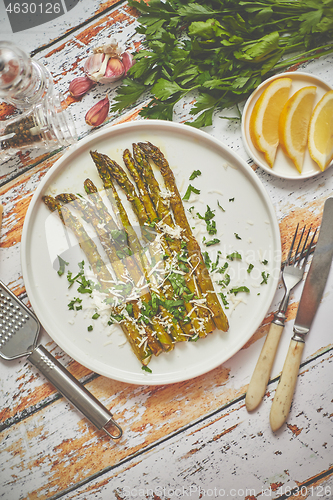 Image of Roasted asparagus with parmesan cheese and parsley. Healthy spri