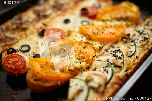 Image of Long baguettes pizza sandwiches with tuna, mushrooms, tomatoes and cheese on a metal baking tray