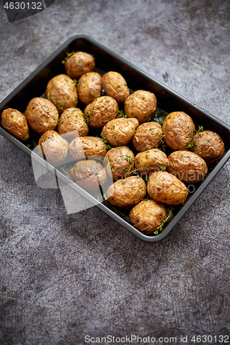 Image of Homemade roasted whole potatoes in jackets. With butter, rosemar