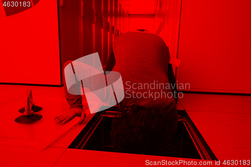 Image of engineer connecting cables in server room