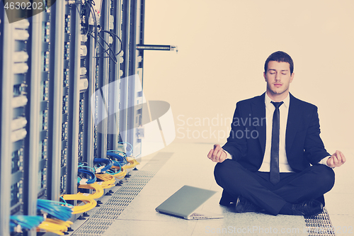 Image of business man practice yoga at network server room