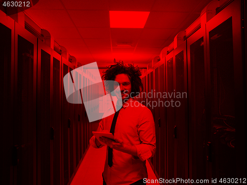 Image of IT engineer working on a tablet computer in server room