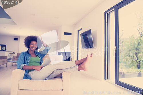 Image of african american woman at home with digital tablet