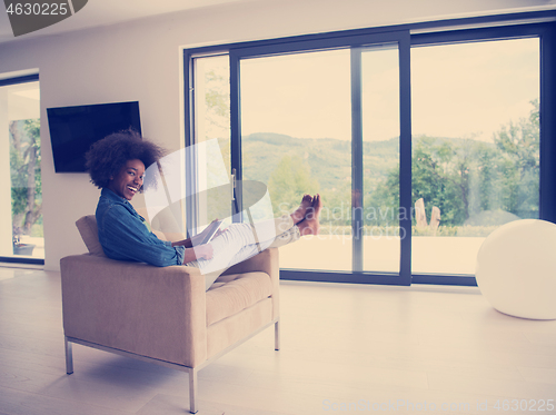 Image of african american woman at home with digital tablet