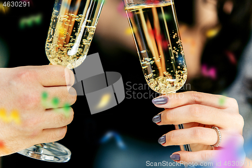 Image of Celebration. Hands holding the glasses of champagne and wine making a toast.