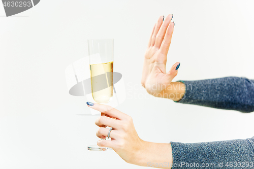 Image of Hand of woman refusing glass with alcoholic beverage, on white background