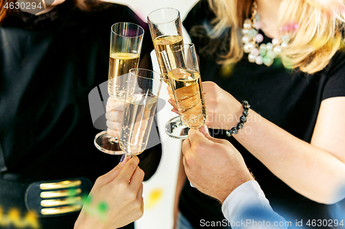 Image of Celebration. Hands holding the glasses of champagne and wine making a toast.