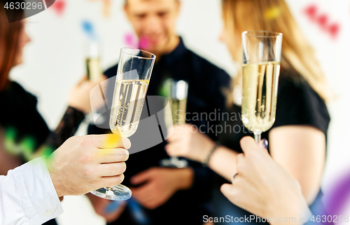 Image of Celebration. Hands holding the glasses of champagne and wine making a toast.