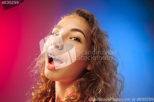 Image of The happy business woman standing and smiling against red and blue background.