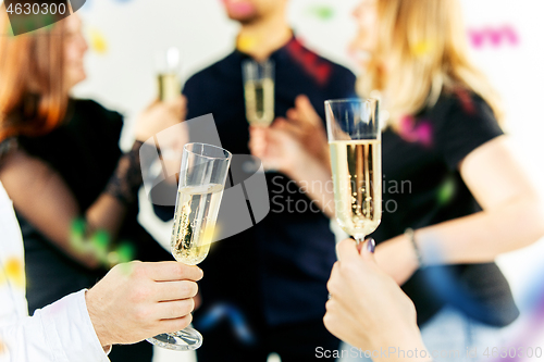 Image of Celebration. Hands holding the glasses of champagne and wine making a toast.