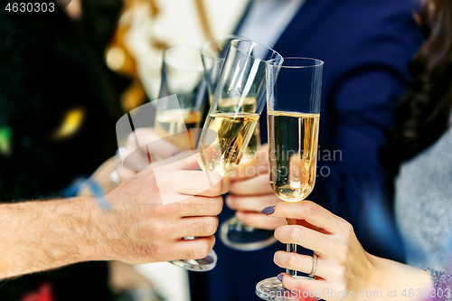 Image of Celebration. Hands holding the glasses of champagne and wine making a toast.