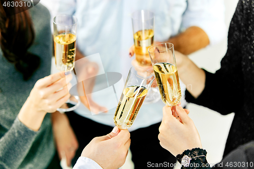 Image of Celebration. Hands holding the glasses of champagne and wine making a toast.