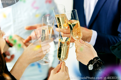 Image of Celebration. Hands holding the glasses of champagne and wine making a toast.