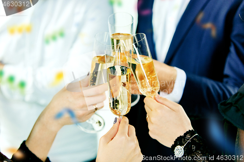 Image of Celebration. Hands holding the glasses of champagne and wine making a toast.